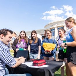 Group of students standing around table
