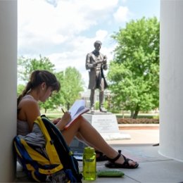 Student reading outside library