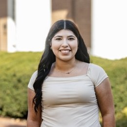 Student standing outside smiling at camera