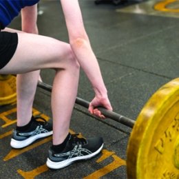student lifting weights in buck fitness center
