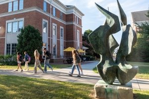 Students walking to class near the flame sculpture