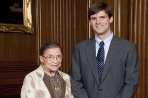 Benjamin Beaton and Ruth Bader Ginsburg standing in an office and smiling at camera