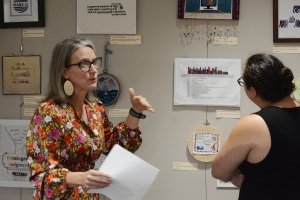 Beth Morgan ’01 talks about the Unseen Labor exhibit at Centre’s Grace Doherty Library as students and staff examine the work on display.