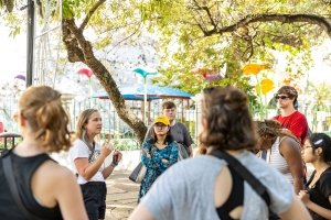 Sarah Egge teaches students surrounding her under branching tree foliage in Puerto Rico.