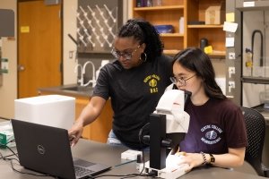 Genevive Bell and Remy Bao conduct research and examine their results in the lab.