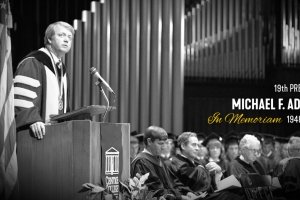 A black and white photos of former Centre College President Michael F. Adams speaking at the Norton Center for the Arts. Text on the photo reads, "19th President Michael F. Adams 1948-2026.