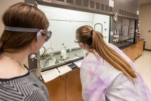 Professor Witt is examining smoke under the hood during an experiment.