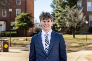 Headshot of Declan Miller on campus. He is wearing a blue suit jacket and tie.
