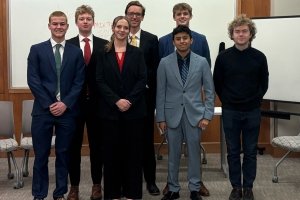 The new mock trial team posing in the court room. It is a group of seven students.