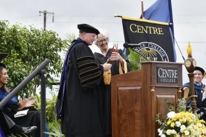 Centre College president Milton C. Moreland hands a glass award to retiring trustee Crit Blackburn Luallen.