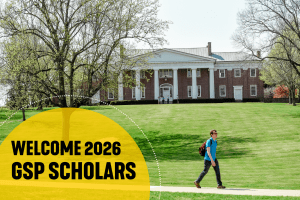 A student walks across campus with Old Centre in the background. Text on the graphic reads "Welcome 2026 GSP Scholars"
