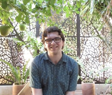 Student sitting in front of bamboo and glass wall