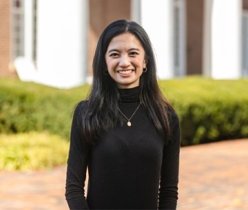 Student wearing black sweater standing outside Old Centre smiling
