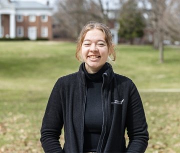 Student standing in front of Old Centre and smiling
