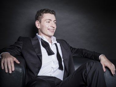 Dominic Cheli sitting in a chair wearing a suit