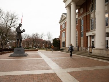student walking in front of library