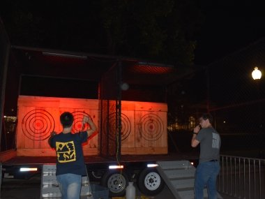 two people throwing axes at a target