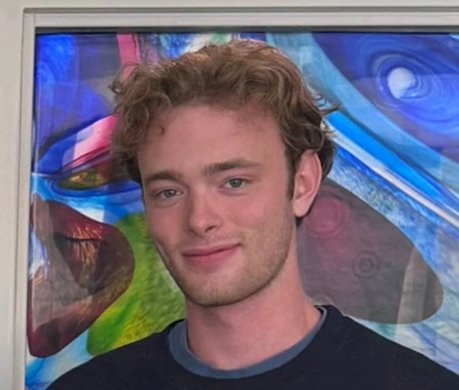 Student standing in front of the stained glass wall at the Intercultural Suite