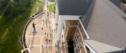 Aerial view of students near campus library with large sidewalks and statue of Abraham Lincoln