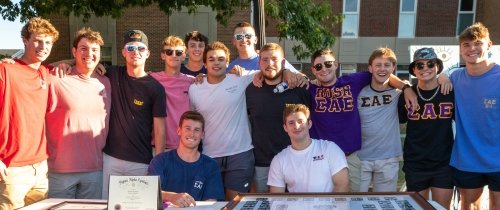 Centre fraternity brothers smiling at the activities expo