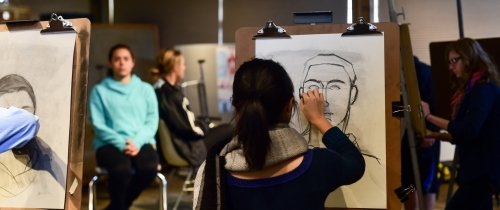 Students working at easels in a life drawing class