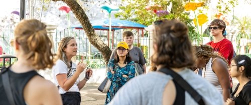 Sarah Egge teaches students surrounding her under branching tree foliage in Puerto Rico.