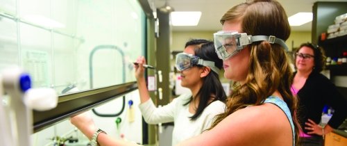 Students participating in a Alzheimer's research project wearing goggles in a lab