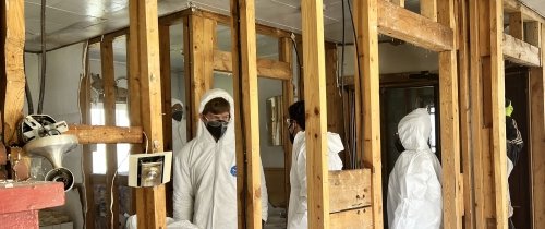 Centre College students dress in white protective overalls as they demo the interior of a North Carolina home affected by flooding.
