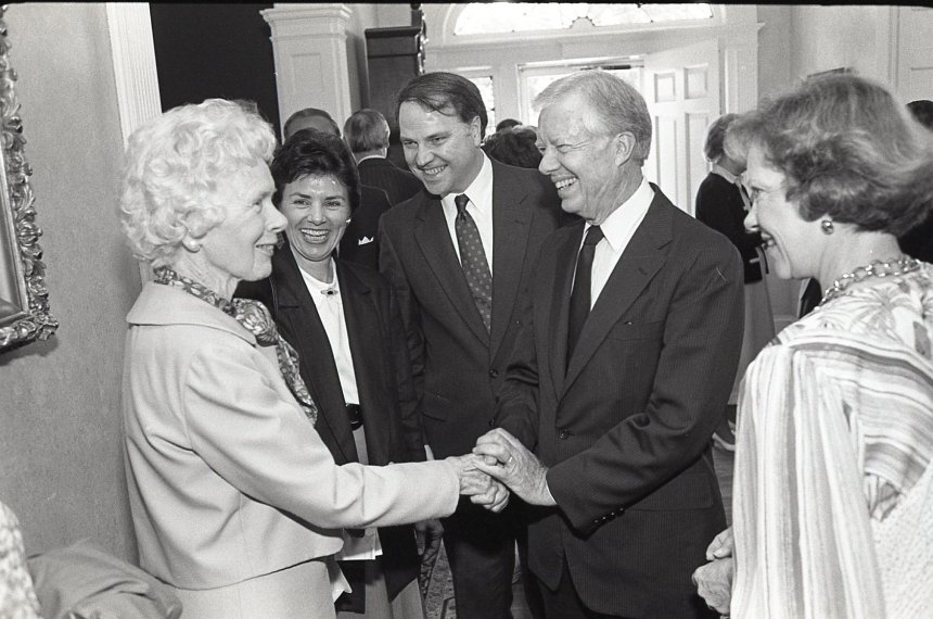 President Jimmy Carter shakes hands with a woman as he is surrounded by Centre College community members.