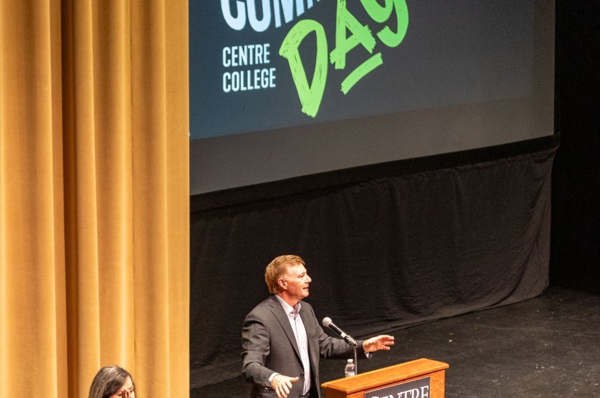 A man stands behind a lectern.