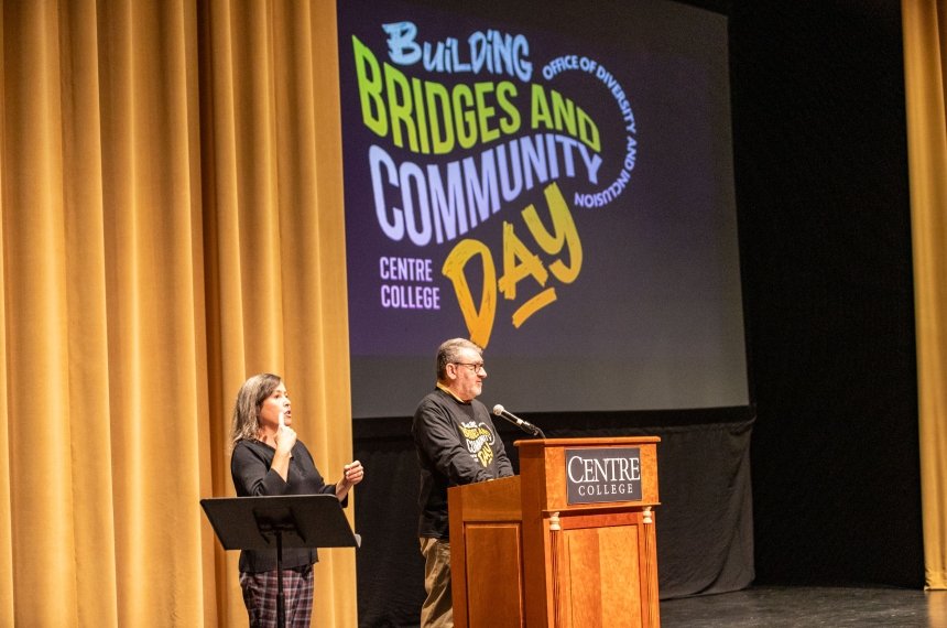 A man addresses an audience from behind a lectern.