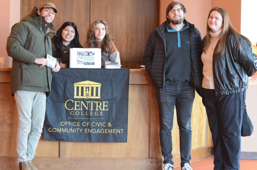 Two men and three women pose for a photo next to a sign that says &quot;Centre College Office of Community and Civic Engagement.&quot;