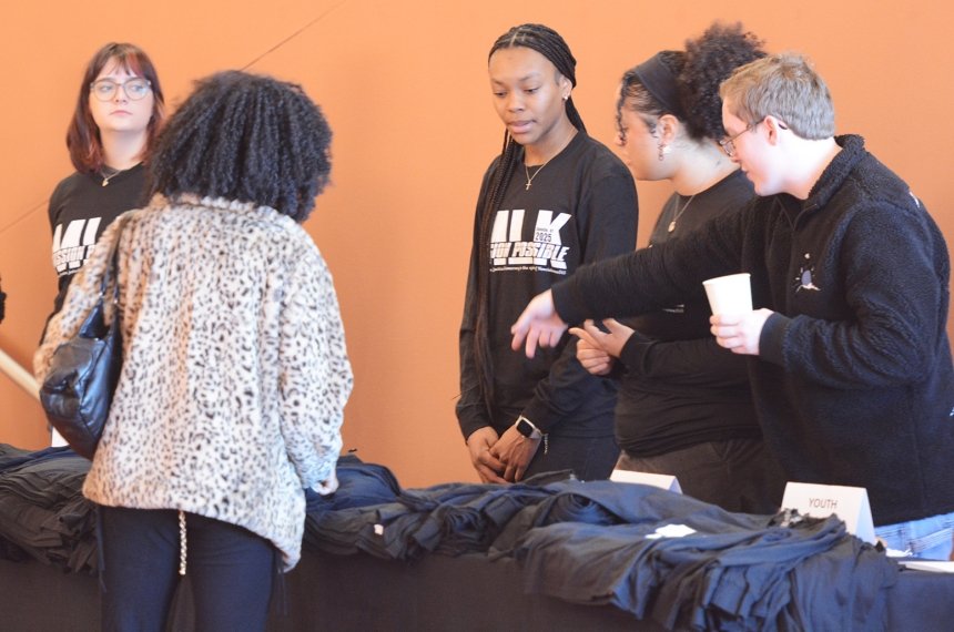 A young woman picks out a Martin Luther King Jr. Day t-shirt as Centre students help her.