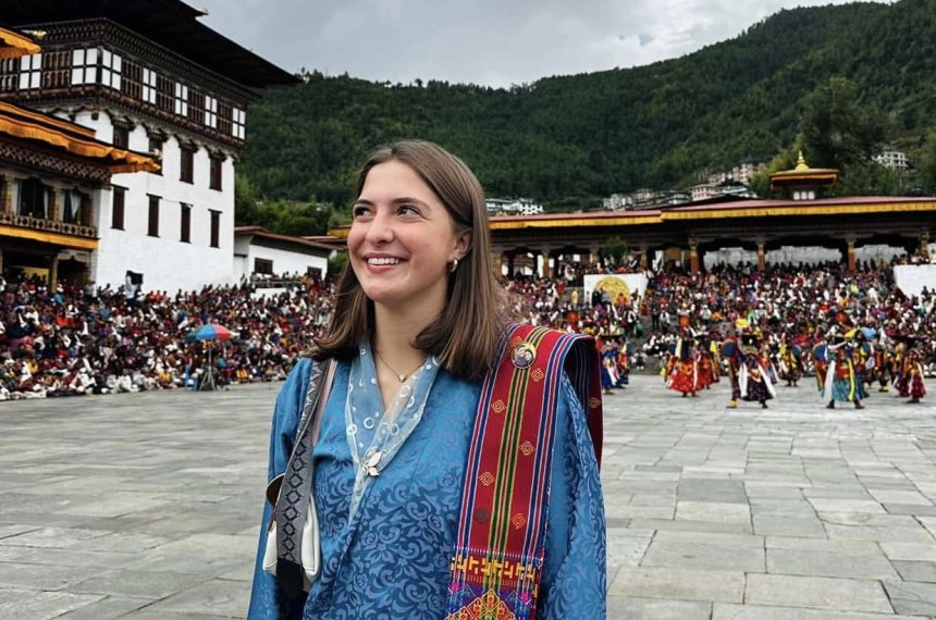 Sophia is at a festival, smiling and taking in all the colors and history.