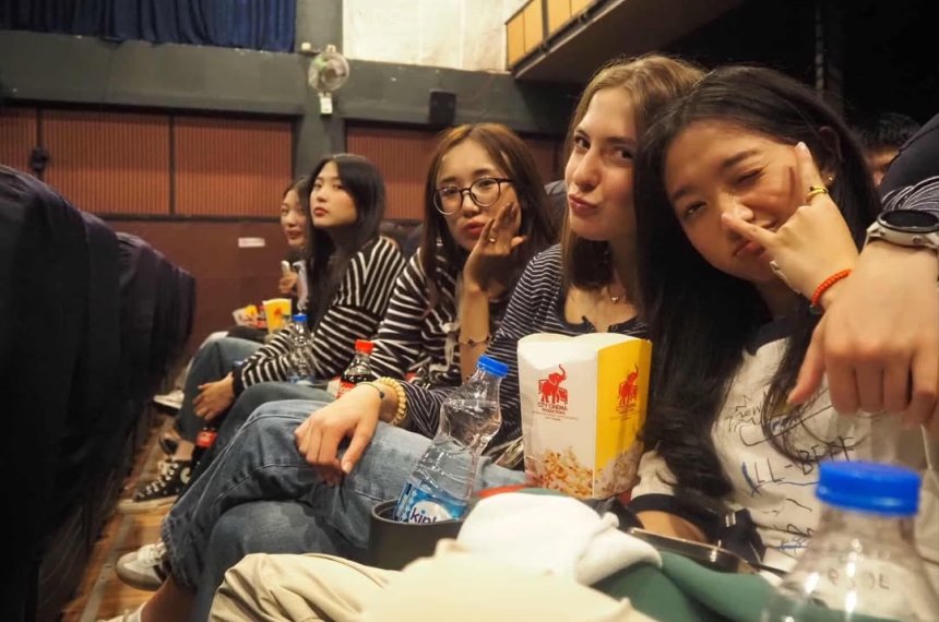 Sophia is smiling and hanging out with friends, enjoying snacks at an event.