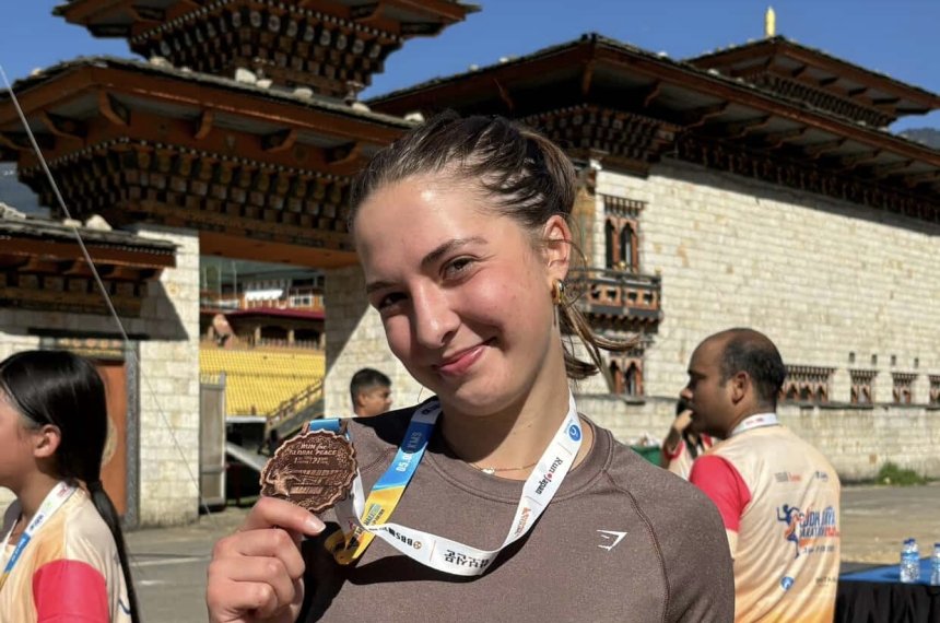 Sophia posing with her medal after a race.