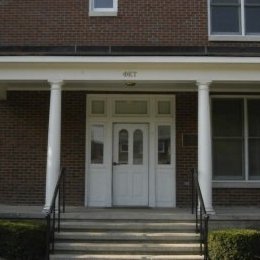 multi level brick home with white doorway and with porch and steps