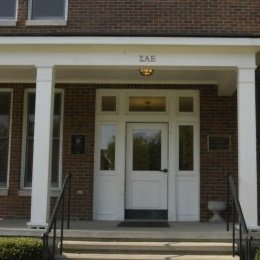 multi level brick home with white doorway and porch with steps leading up to porch