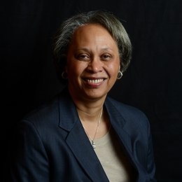 Person wearing navy suit coat smiling 