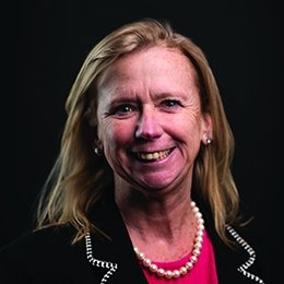 Person wearing dark suit jacket smiling