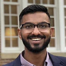 Person with glasses wearing suit jacket smiling 