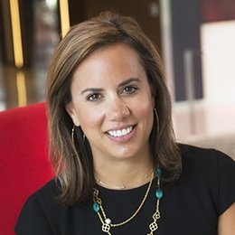 Person wearing black top sitting in red chair smiling
