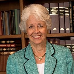 Person standing in front of bookshelf smiling