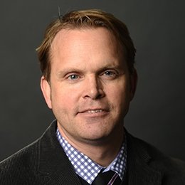 Person wearing dark jacket smiling 