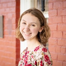Lady with short brown hair wearing floral top on front porch of ODI building