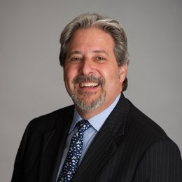 Person wearing dark suit smiling