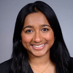 Person in front of blue background smiling 