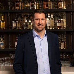 Person standing in front of wall of bourbon bottles 