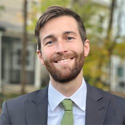 Person wearing suit standing outside smiling 