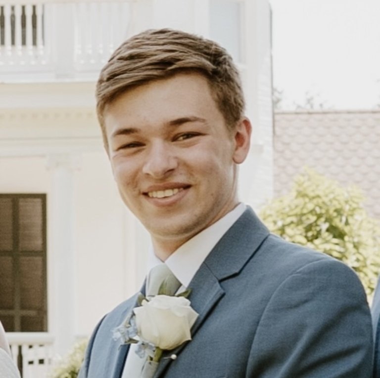 A man in a suit and tie smiles for a photo.